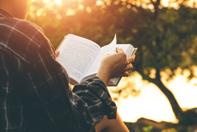 Midsection of woman reading book