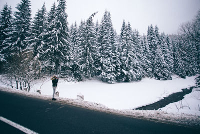 Man on snow covered field against sky