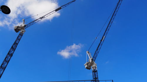 Low angle view of crane against blue sky