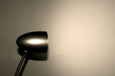 Close-up of illuminated electric lamp against wall