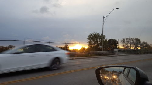 Car on road against sky at sunset