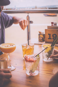 Cropped image of friends having drinks on table in restaurant