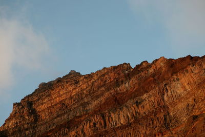 Low angle view of rocky mountains against sky