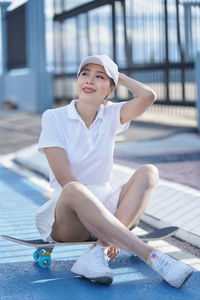 Portrait of smiling young woman sitting on floor