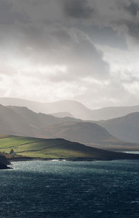 Scenic view of mountains against cloudy sky