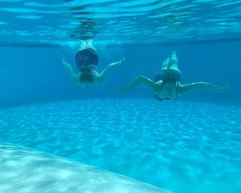 Portrait of woman with friend swimming in pool