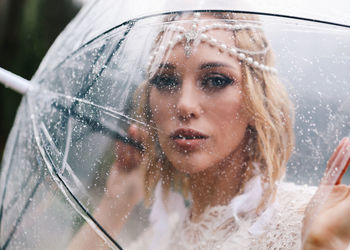 A beautiful young woman bride in a wedding lace dress stands in the middle of a lake and mountains