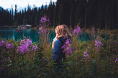 Rear view of woman against purple flowering plants