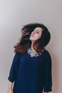 Young woman standing against wall at home