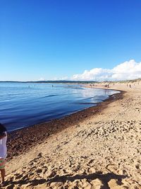 Scenic view of beach against clear blue sky