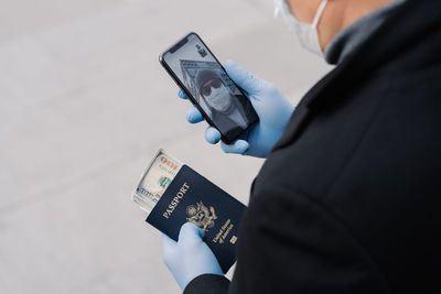 Midsection of man using mobile phone