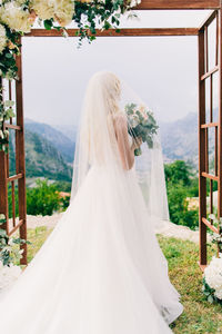 Rear view of woman holding white flowers