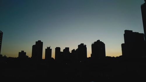 Silhouette buildings against sky during sunset