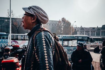 Man standing on stage in city against sky