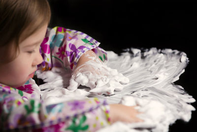 Close-up of cute girl sleeping against black background