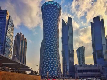 Low angle view of modern building against cloudy sky