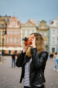 Female traveler taking picture with vintage instant camera