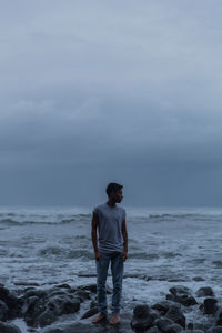 Full length of man standing on beach against sky