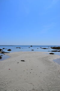 Scenic view of beach against clear blue sky