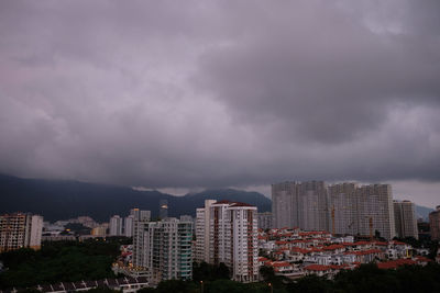 Buildings in city against cloudy sky