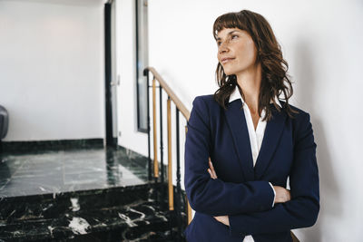 Successful businesswoman standing on staircase