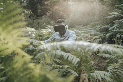 Man using virtual reality headset while exploring forest