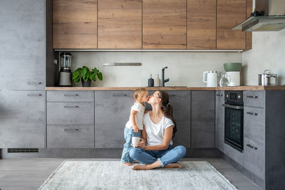 Side view of woman sitting at home