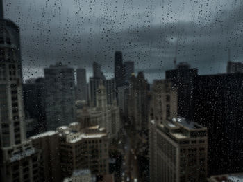 City seen through wet window during rainy season