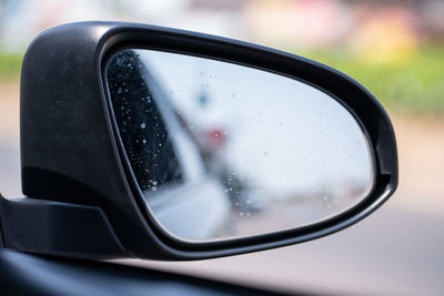 Close-up of raindrops on side-view mirror