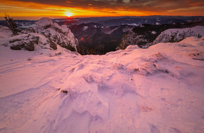 Scenic view of snow covered mountains against sky during sunset in ceahlau mountains 