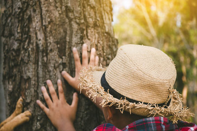 Rear view of people against tree trunk