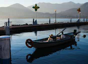 Boats moored on sea against mountains