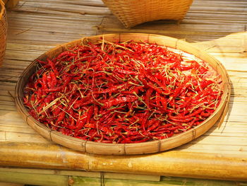 High angle view of red chili peppers in basket on table