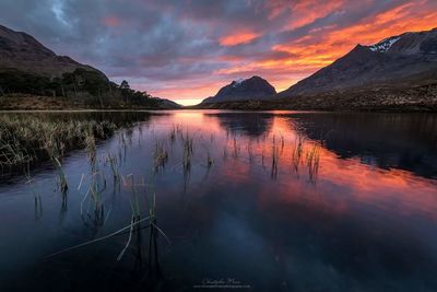 Scenic view of calm lake at sunset