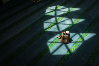 High angle view of man praying in mosque