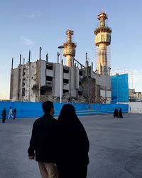 Woman standing in front of built structure