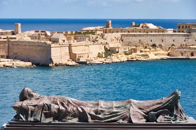 High angle view of statue against castle and sea