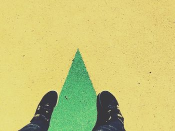 Low section of person standing on tiled floor