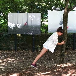 Side view of woman on field against trees