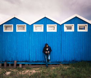 Photographer checking photos resting behind a sea hut