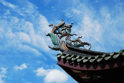Low angle view of sculpture against blue sky