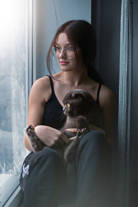 Portrait of young woman sitting on bed at home