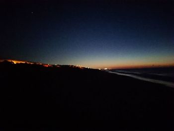 Silhouette landscape against clear sky at night