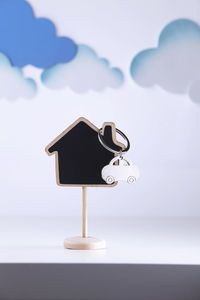 Close-up of model home with clouds against white background