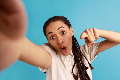 Woman pointing against blue background