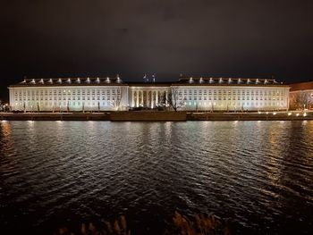 River with illuminated buildings in background at night