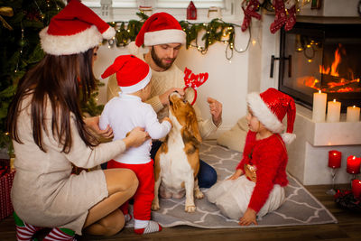 Side view of woman with dogs at christmas tree