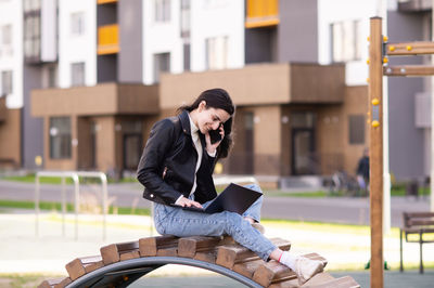 Side view of young man using mobile phone