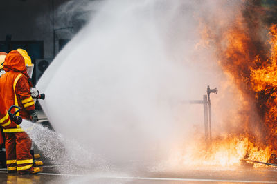 Firefighters spraying water on fire on street