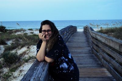 Young woman on shore at beach against sky